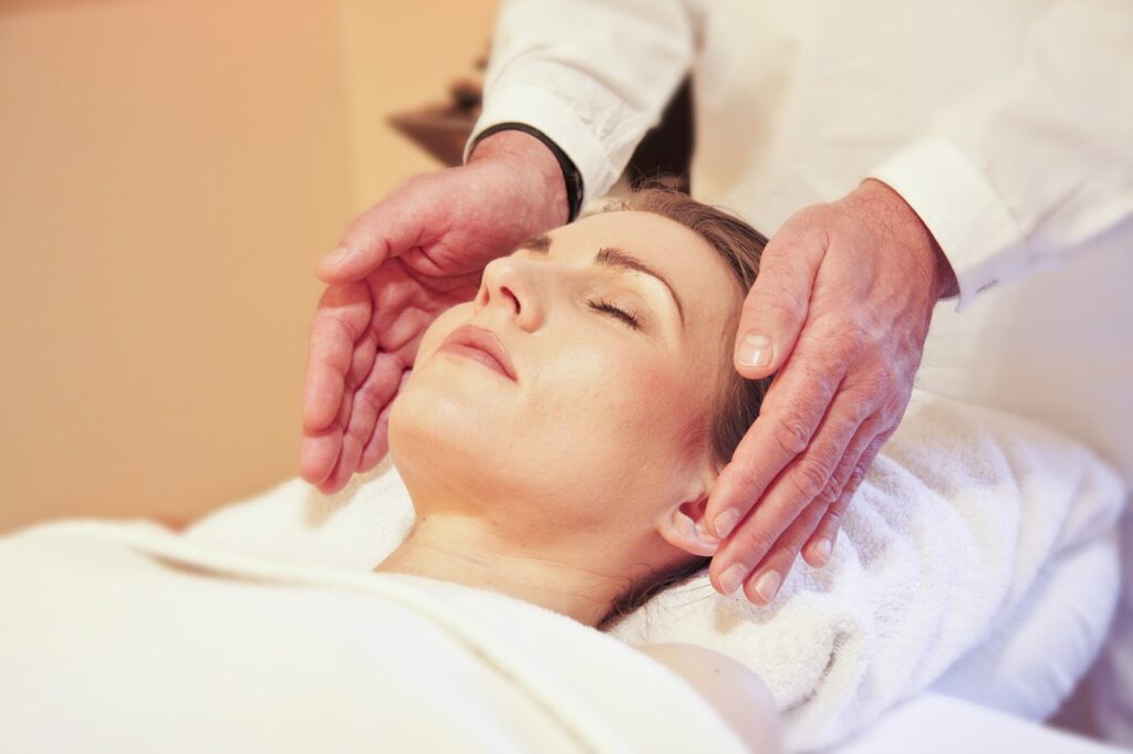 Reiki practitioner channeling healing energy with hands positioned over a client in a peaceful healing session